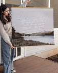 Woman holding the large All Things Work Together landscape scripture print to show its scale.