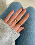 Ribbon Bow Ring styled with another gold-tone ring above blue jeans.