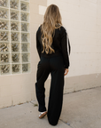 Back view of black varsity stripe crewneck and sweatpants set