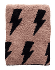 Folded towel with black lightning bolt pattern on a light brown background