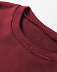 Close-up of the burgundy Sportie pullover showing its ribbed crew neckline.