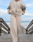 Heather Eggshell Basics sweatpants styled with a coordinating zip hoodie on a beach boardwalk.