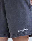 Navy shorts with 'Elevated Faith' branding on a light gray background