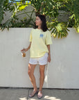 Model wearing the oversized Morning Sun Be the Light tee with white shorts outdoors