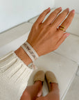 Beige WWJD Embroidered Bracelet worn on a wrist with a cream knit sleeve
