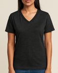 Indian female model wearing a dark gray Bella + Canvas V-Neck T-Shirt on a light tan background — soft cotton-poly blank ideal for custom printing by Lumiere Vive.