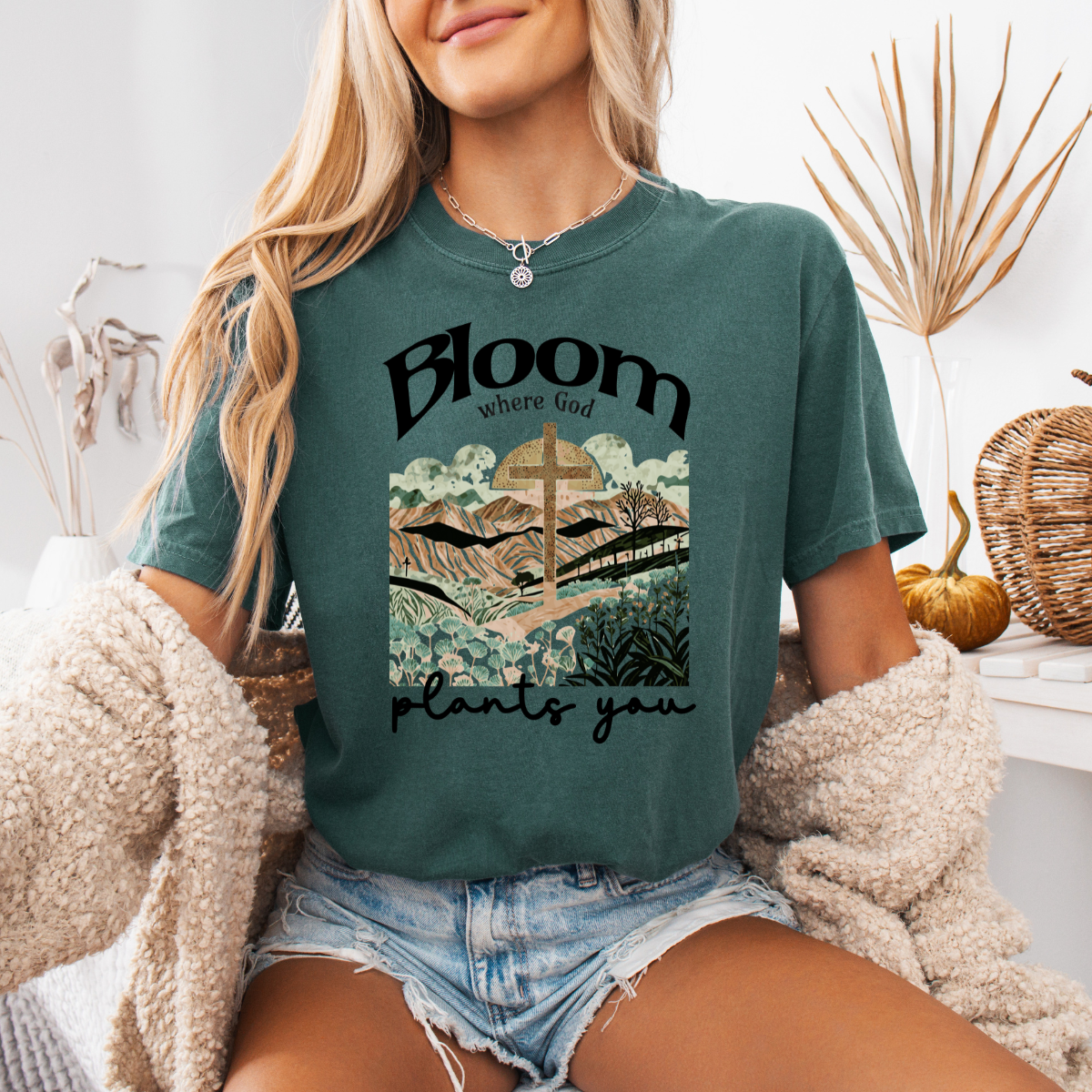 Person wearing a green t-shirt with a graphic design and text, sitting indoors.