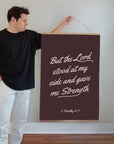 Man holding But the Lord Stood 24 by 36-inch Scripture wall art with a wooden hanging banner
