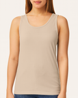 Female model wearing a neutral sandstone Comfort Colors C9360 Garment-Dyed Tank on a beige background — soft cotton tank ideal for custom printing by Lumiere Vive.