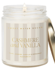 Cashmere and Vanilla candle in a clear glass jar with a neutral striped gold foil label and gold-tone lid