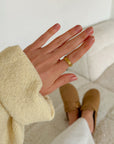Hand wearing a gold-tone Celestial Ring beside a cream sleeve