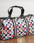 Duffel bag with smiley face pattern on a wooden floor