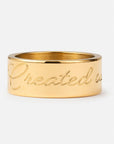 Gold ring with 'Created with' engraving on a white background