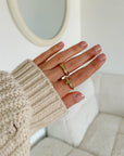 Gold-tone cross ring and matching band styled with a cream sweater