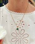 Emerald Agape Cross Pendant Necklace worn with a white eyelet blouse