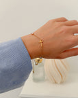 Everlight cross link bracelet worn on a wrist with a blue sleeve