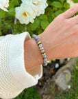 Faith Hope Love beaded bracelet worn on a wrist beside white flowers