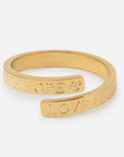 Gold bracelet with engraved text on a white background