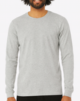 Male model wearing a heather gray Gildan G540 Heavy Cotton Long Sleeve T-Shirt on a white background — classic crew neck style ideal for custom printing by Lumiere Vive.
