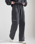 Front view of black God of Miracles sweatpants showing the relaxed wide leg silhouette.
