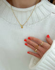 Heart Lock Paperclip Chain Necklace styled with a white sweater and gold-tone rings.