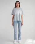 Full-length view of the His Love Endures Forever tee styled with jeans and white sneakers