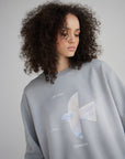 Close-up of a woman wearing the Pearl Blue sweatshirt with a pastel cross and His Love Endures Forever lettering