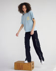 Angled view of the boxy Sterling Blue Holy Ghost tee styled with dark pants
