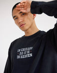 Close view of In Chicago as It Is in Heaven chest lettering on a black long sleeve tee