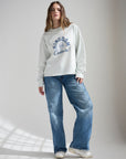 Full-length view of a woman wearing the Illusion Blue Kingdom Culture tee with wide leg jeans.