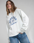 Woman styling the relaxed Kingdom Culture long sleeve tee with blue jeans and one hand in her pocket.
