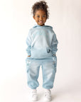 Child wearing Air Blue Kingdom Kids cargo sweatpants with a coordinating top