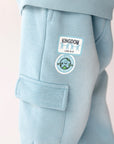 Close-up of cargo pocket and Kingdom Kids graphics on Air Blue sweatpants