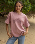 Model wearing the boxy Ash Rose Love Your Neighbor Heavyweight Tee with blue jeans outdoors