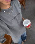 Close view of grey Not Sorry Jesus Is King tee styled with jeans and a necklace