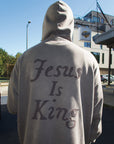 Back view of the Spire Grey hoodie with the hood raised and oversized tonal Jesus Is King lettering