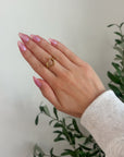 Close-up of Open Heart Ring worn on a hand with pink nails