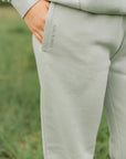 Light gray sweatshirt and pants worn by a person in a grassy field