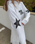 Close view of Pray First lettering and black star sleeve detail on a Heather Grey Hoodie
