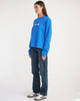 Side view of a woman wearing the blue Pray for Los Angeles heavyweight long sleeve tee.