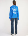 Full-length back view of the Strong Blue Pray for Los Angeles tee styled with jeans.
