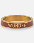 Gold and red bracelet with 'WONDER' text on a white background