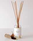 Hello Fall Clear Reed Diffuser styled with autumn leaves on a light background