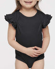 Child wearing a black onesie with ruffled sleeves on a white background