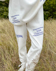 Person wearing a white outfit with text in a natural setting
