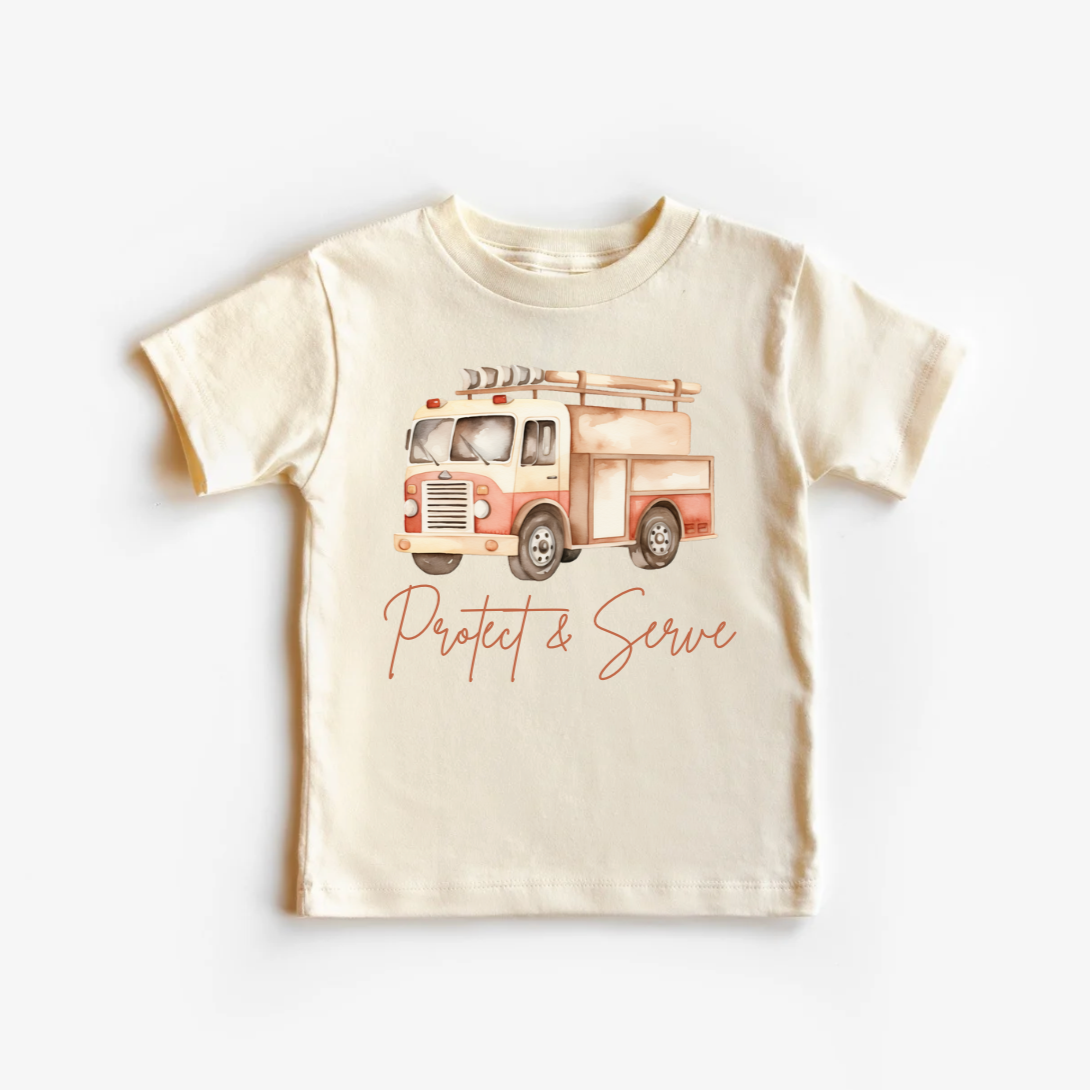 A beige neutral tee shirt top with a print of a fire truck and the text 'PROTECT & SERVE' on the front.