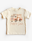 A beige neutral tee shirt top with a print of a fire truck and the text 'PROTECT & SERVE' on the front.