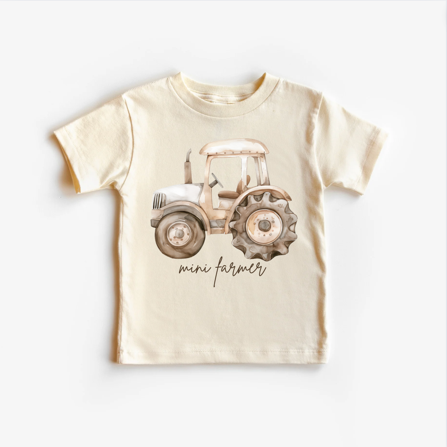 A beige neutral tee shirt top with a graphic print of a tractor and the text 'Mini Farmer' on the front.