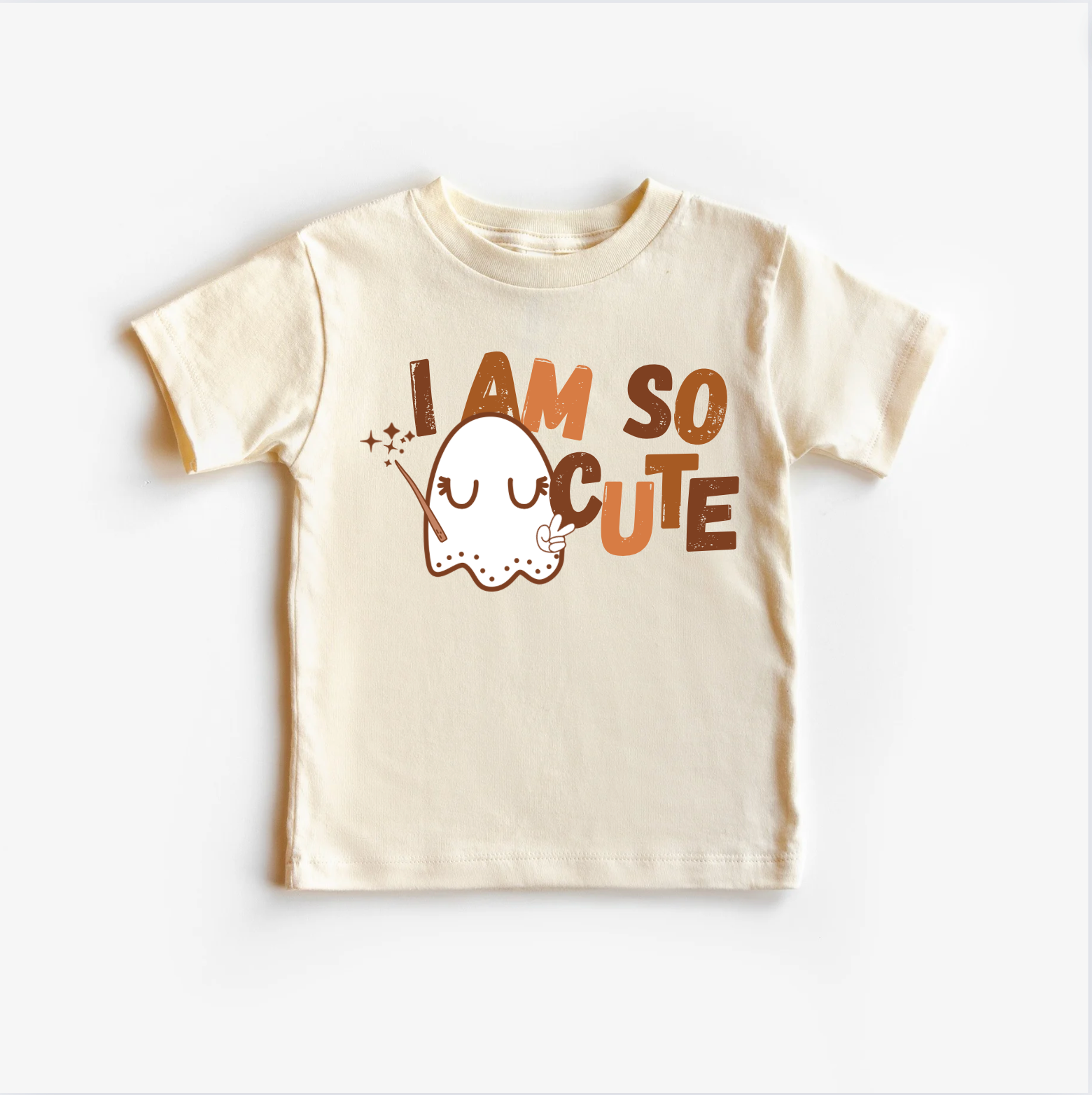 A beige neutral-colored t-shirt top with a cute ghost graphic and the text 'I am so cute' printed on the front.