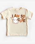 A beige neutral-colored t-shirt top with a cute ghost graphic and the text 'I am so cute' printed on the front.